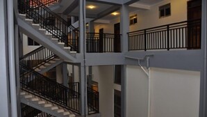A multi-level interior with a staircase and railings. - EKA Hoima Hotel (Hoima)