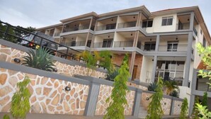 A multi-story hotel with balconies, a stone facade, and a staircase leading to the entrance. - EKA Hoima Hotel (Hoima)