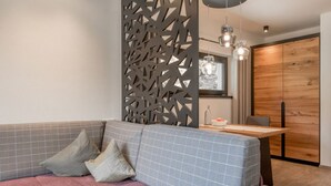 Una sala de estar moderna con un sofá, un mueble de madera y un comedor.
