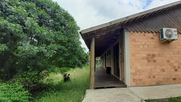 A building with a brick exterior and an open doorway leading to an interior space.