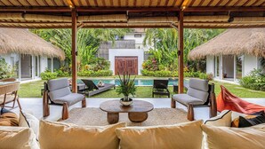 Un espace extérieur aménagé, abrité et doté de chaises longues et d’une piscine.