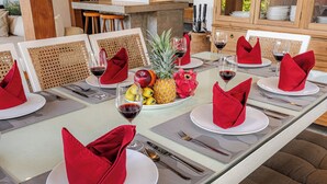 A dining table set with red napkins, white plates, and a fruit centerpiece. - Central Oberoi, Seminyak - Newly Refurbished Villa A (Seminyak)