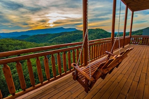 A wooden deck with a swing chair overlooking a forested mountain range. - Splash Manor: Indoor Pool, Spectacular Views, Theater, Games, near Attractions (Sevierville)