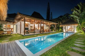 A poolside area with a covered seating area, a pool, and a thatched-roof structure. - Villa Thiara Oberoi Seminyak 500m Kudeta beach (Seminyak)