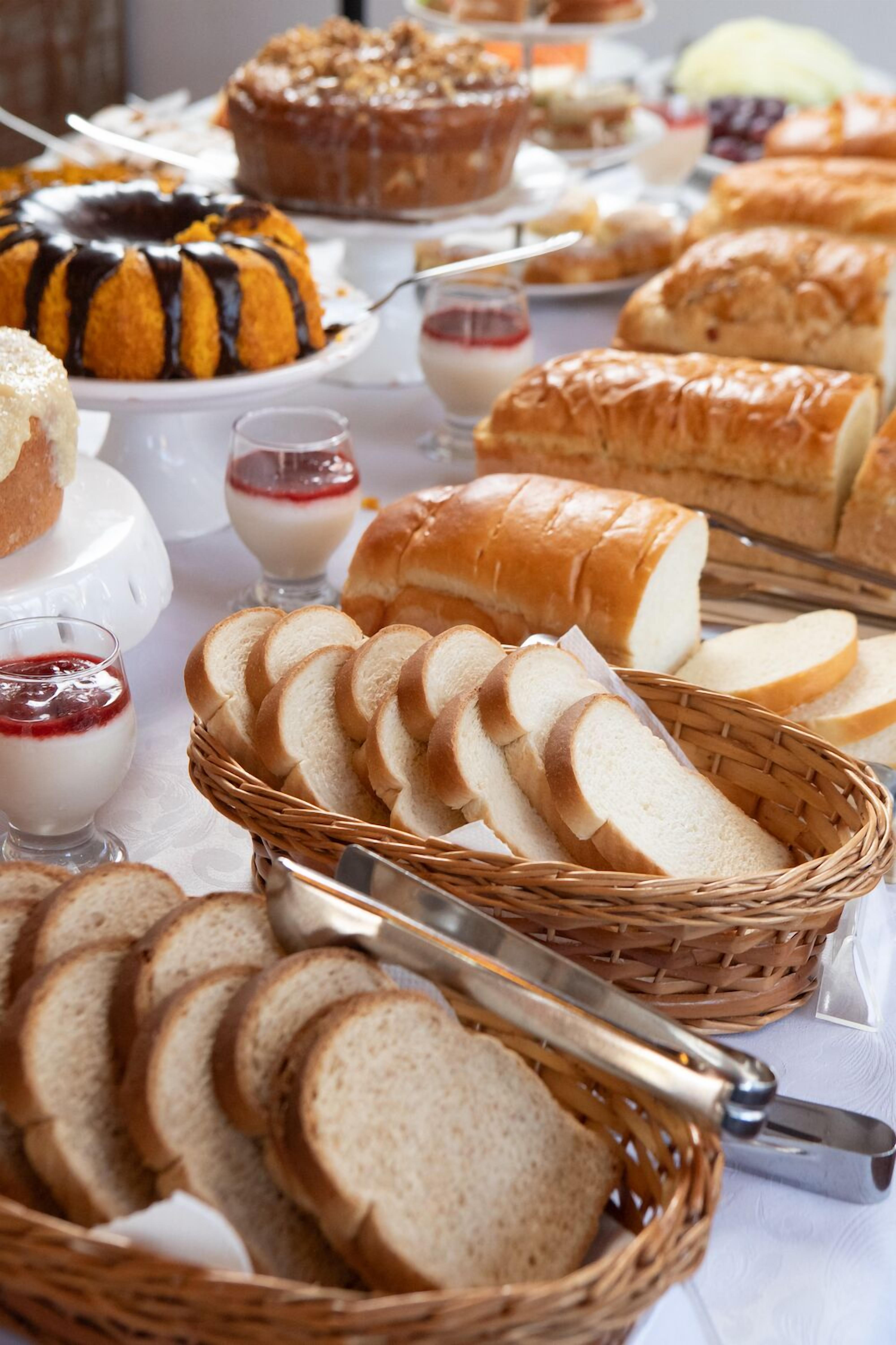 Un tavolo per buffet con diversi tipi di pane, dolci e dessert.