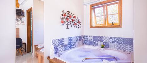 A modern bathroom with a freestanding bathtub, a wooden vanity, a mirror, and a decorative wall piece.