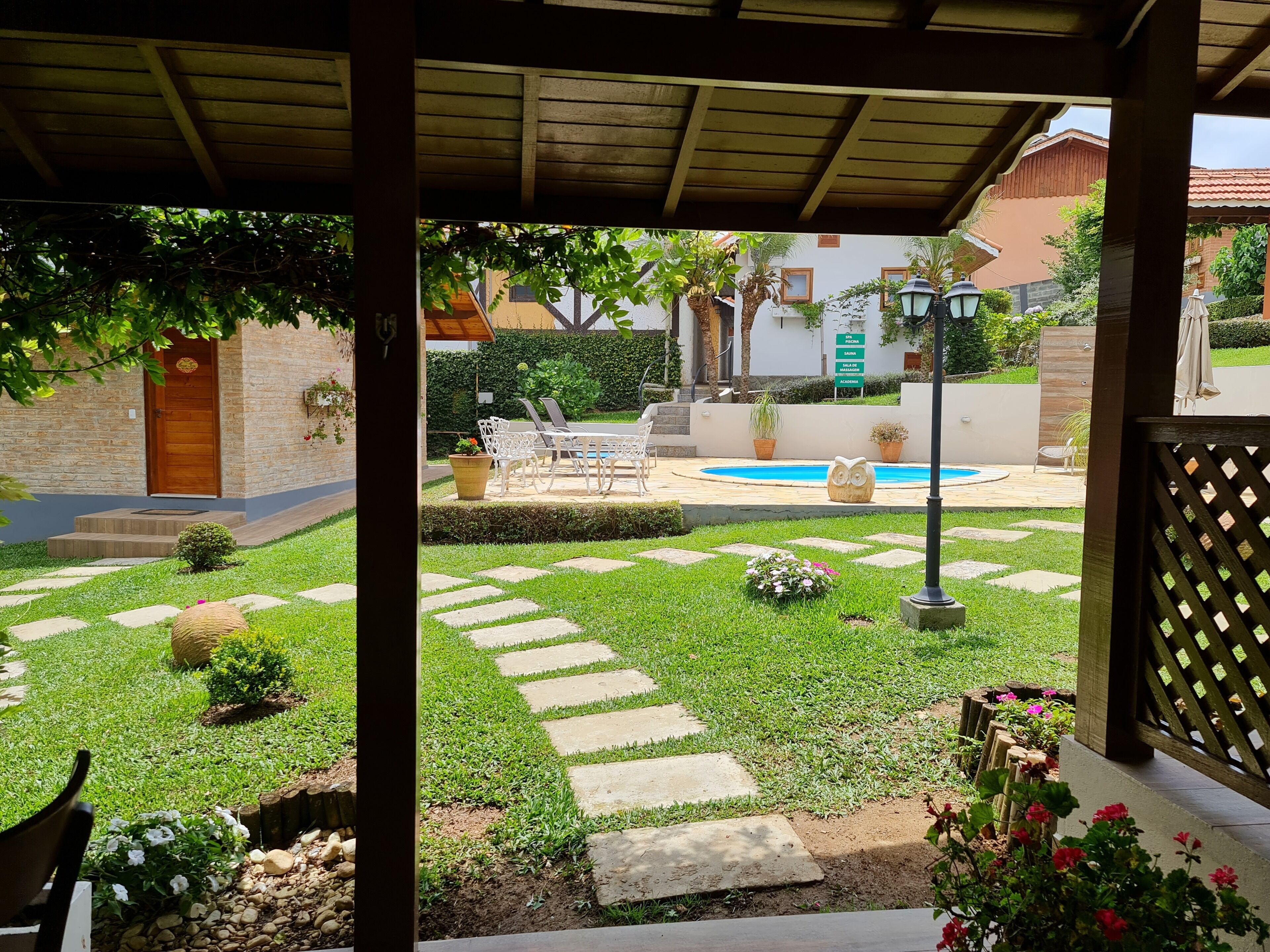A courtyard with a pool, stone pathway, and outdoor furniture.