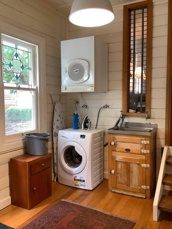 A laundry room with a washing machine, a dryer, and a small cabinet.