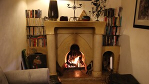 A cozy room with a fireplace, bookshelves, and a comfortable seating area. - Riad Villa El Arsa (Marrakech)