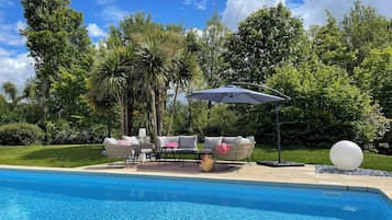 Piscine couverte, piscine extérieure, parasols de plage, chaises longues