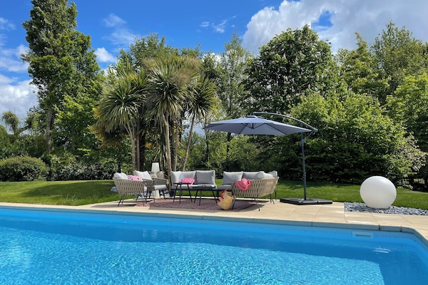 Una piscina techada, una piscina al aire libre, sombrillas