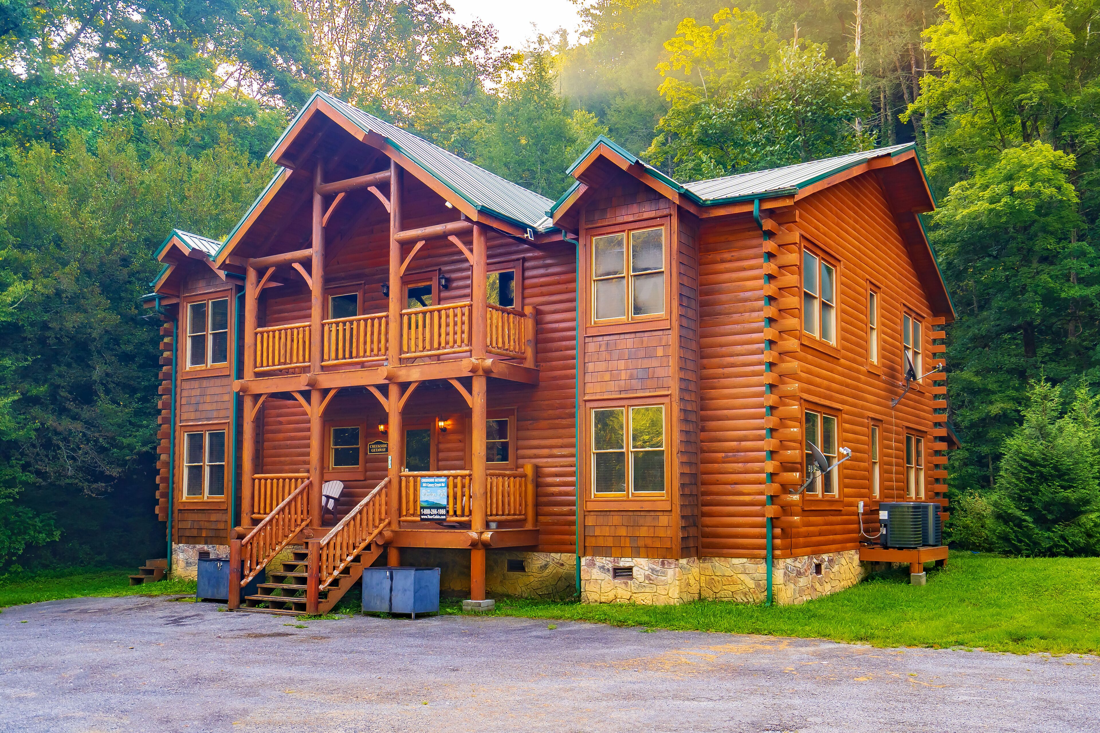 Een houten chalet met een balkon en een trap naar de ingang.