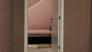 Quarto com cama, porta e tapete de boas-vindas.