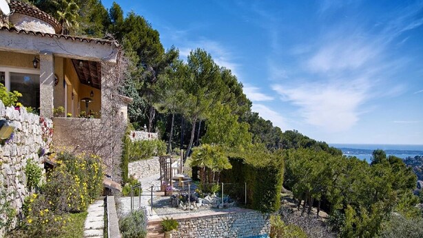 Een luxe villa met een privézwembad, stenen muren en een prachtig uitzicht over het omliggende landschap.