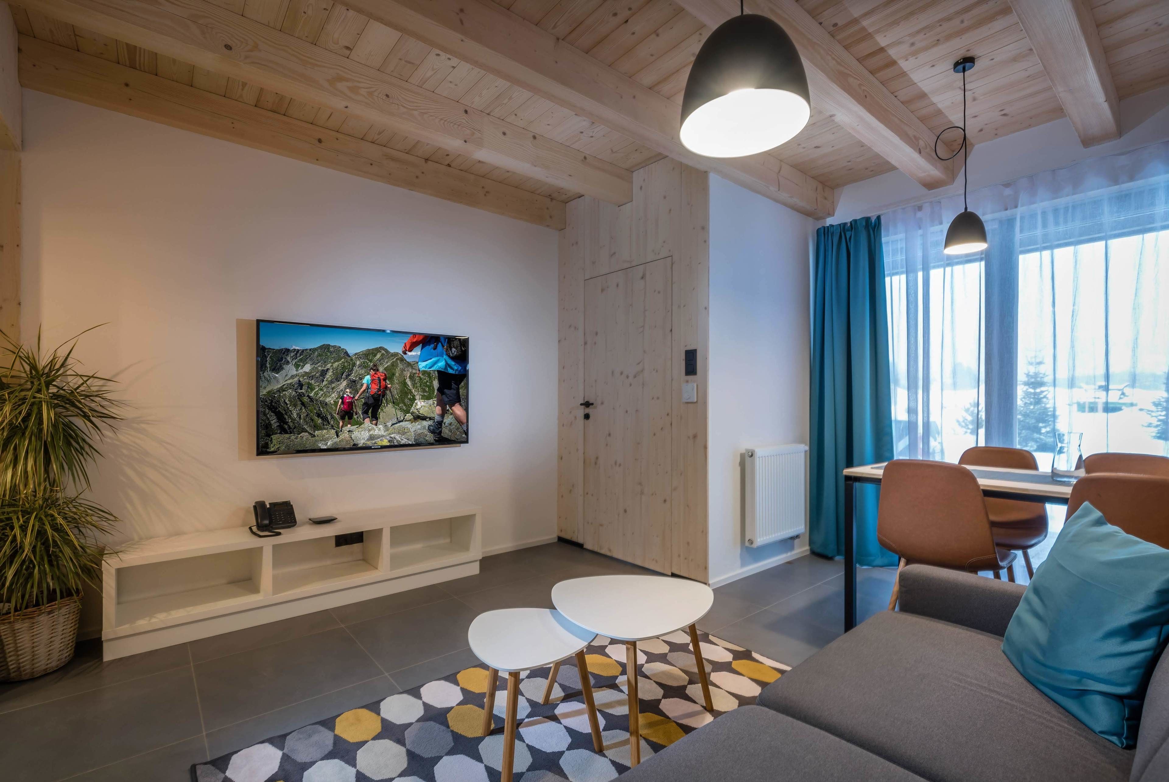 A modern living room with a TV, sofa, and dining area.