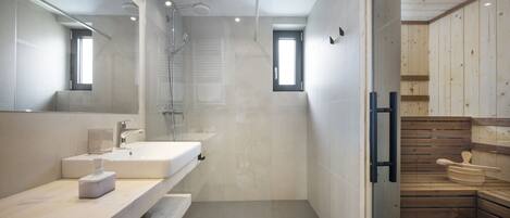 A modern bathroom with a large mirror, a sink, and a shower area.