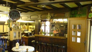 Eine Bar mit Stehtischen, einer Theke und einer Kreidetafel-Speisekarte.