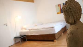 Ein Schlafzimmer mit einem Bett, einem Nachttisch und einer Statue.