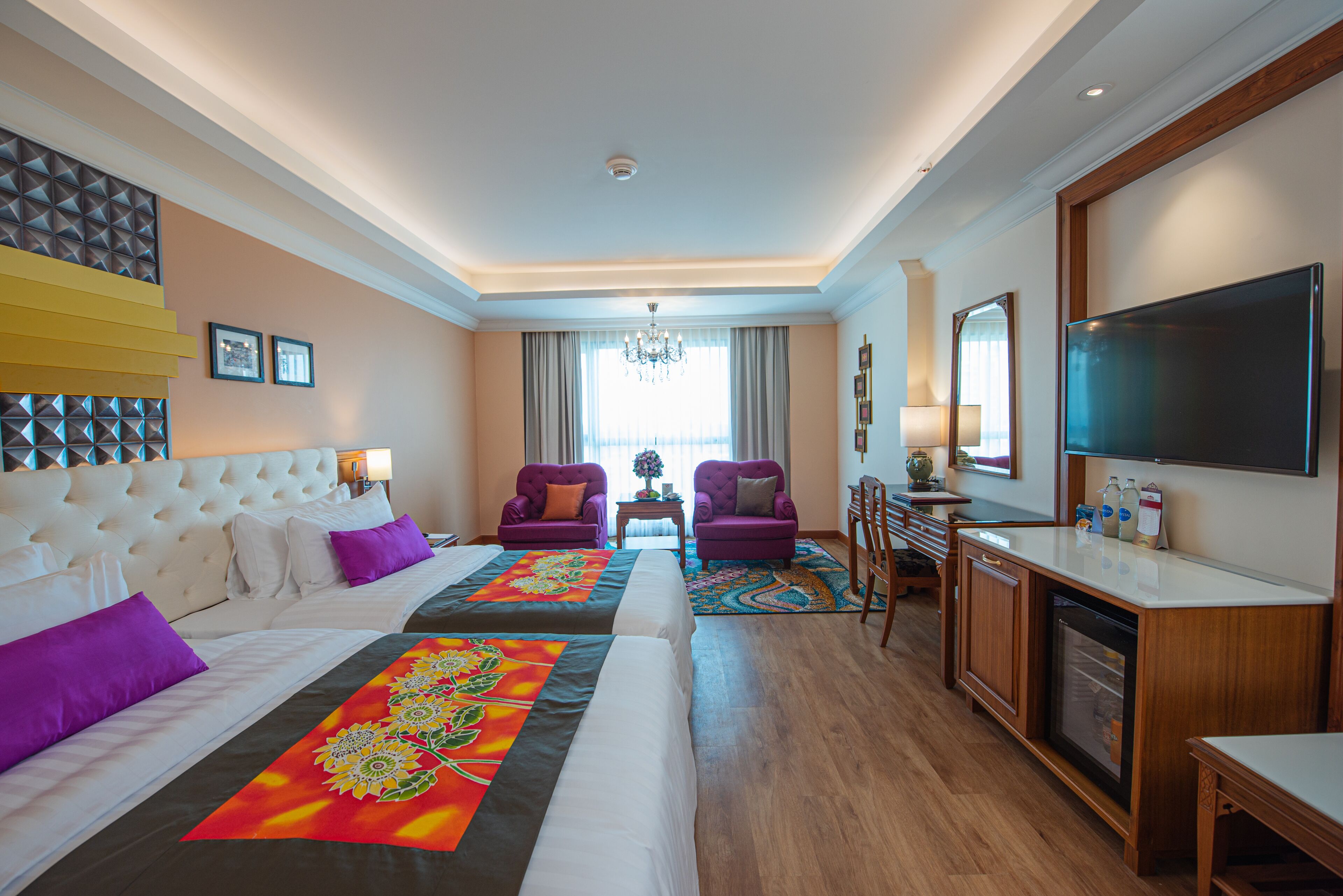 Habitación de hotel con dos camas, un comedor y un televisor.