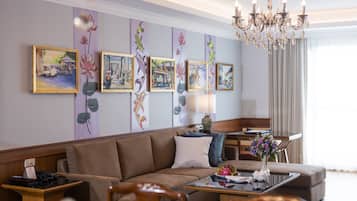 A modern hotel room with a sofa, a coffee table, and a chandelier.