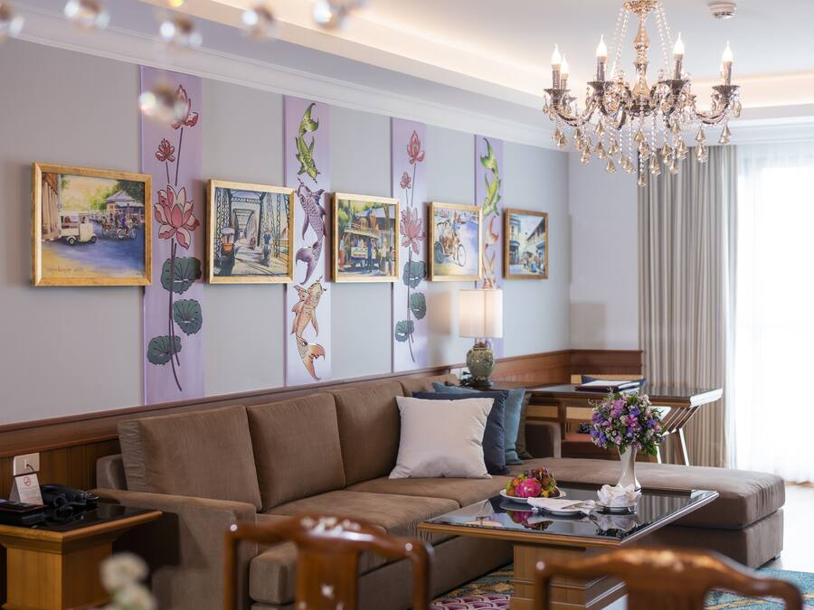 A modern hotel room with a sofa, a coffee table, and a chandelier.