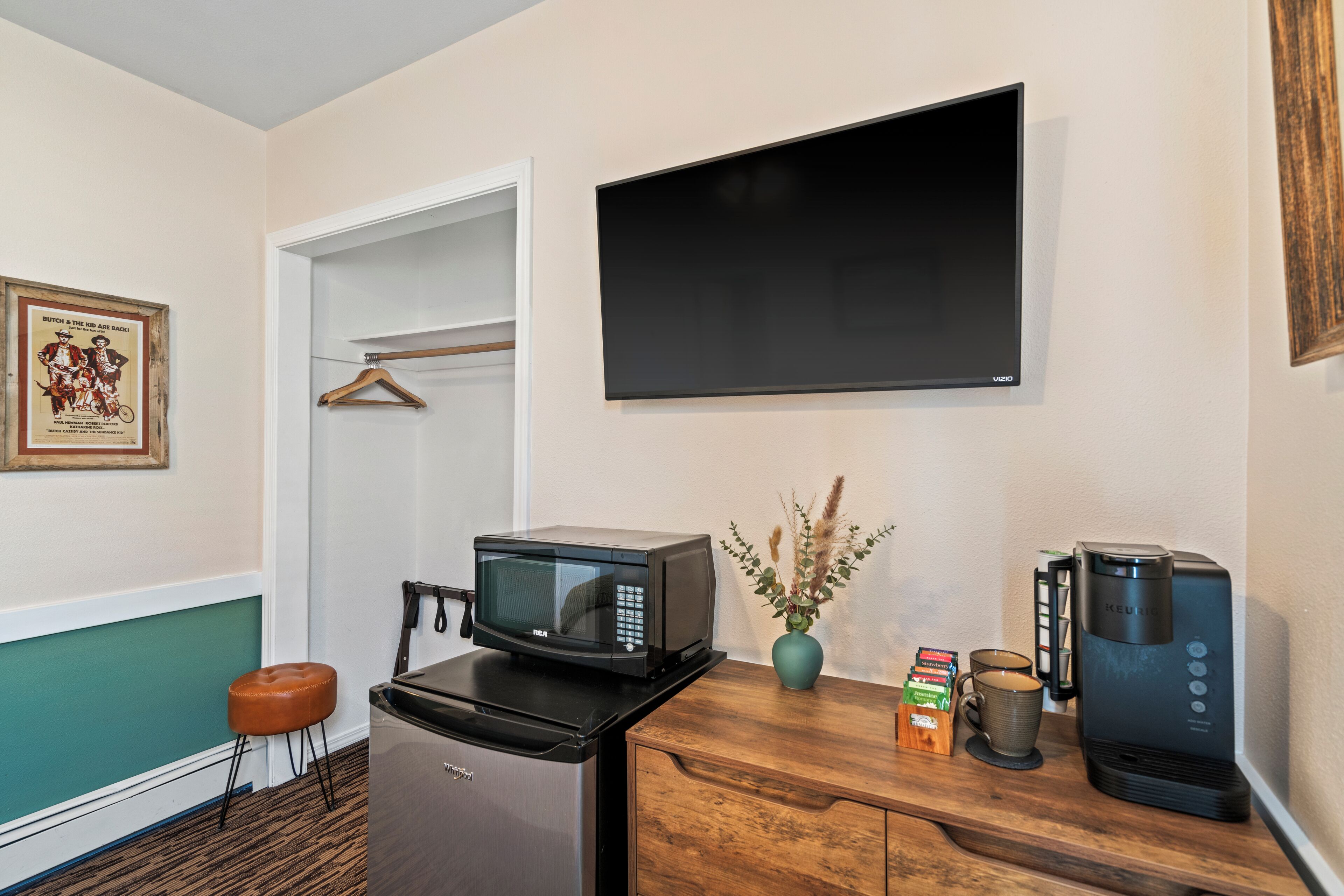A kitchenette with a microwave, coffee maker, and a small cabinet.