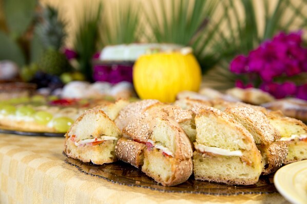 Ein Tisch mit verschiedenen Speisen, darunter Sandwiches und Früchte.