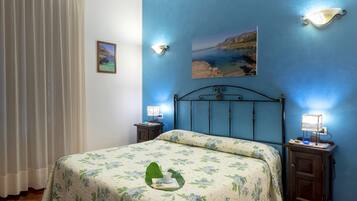 Un dormitorio con una cama, dos mesitas de noche, una lámpara de pared y un cuadro.