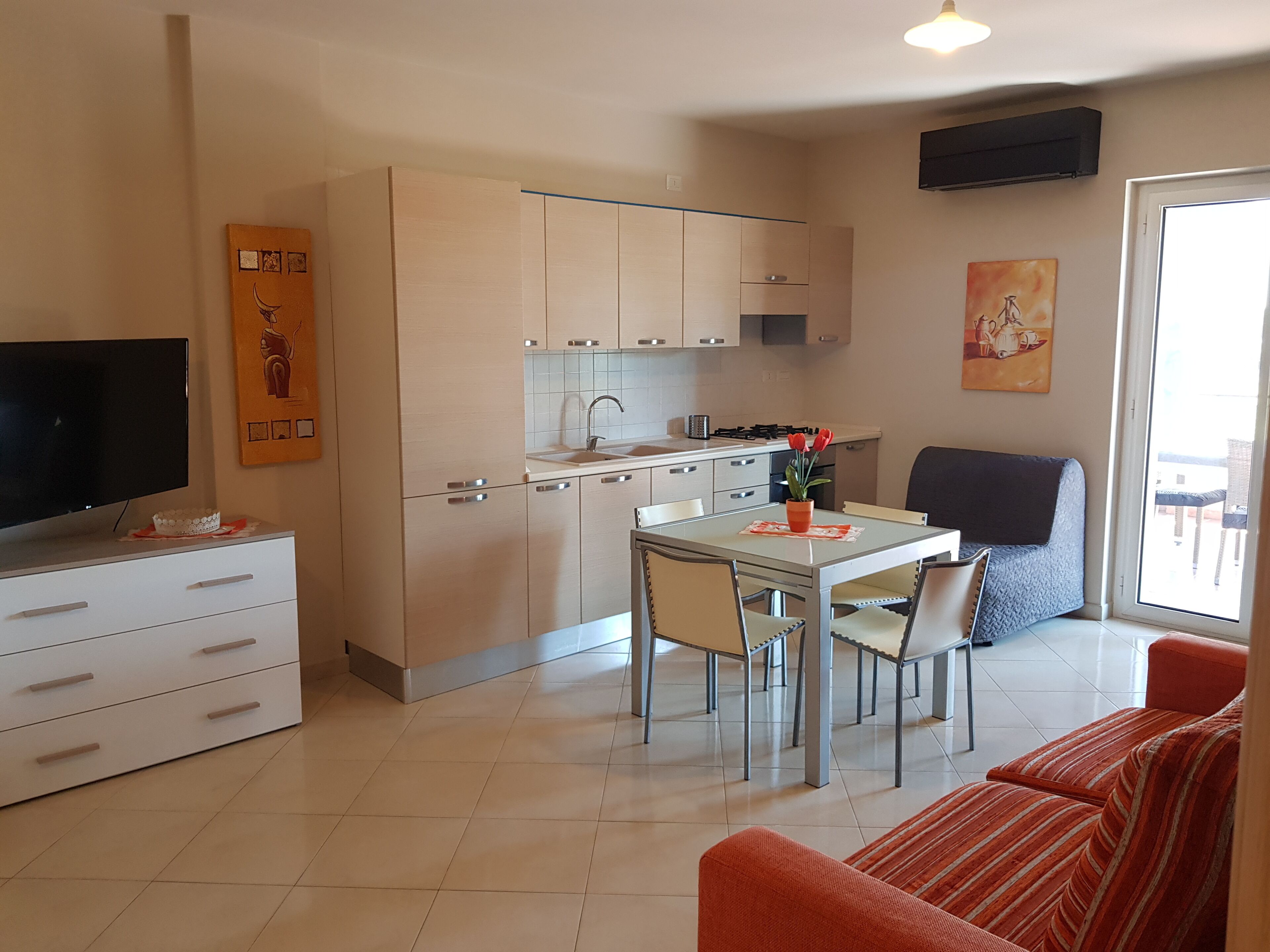 A compact living space with a kitchenette, dining area, and a sofa.