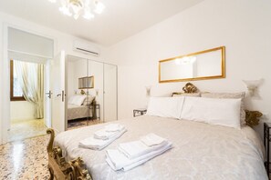 A hotel room with a bed, a mirror, and a door leading to a bathroom. - Ca Maria, bright and quite apartment in Venice (Venezia)