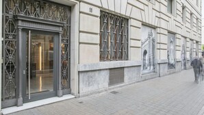 Un bâtiment doté d’une grande entrée en verre, d’une grille métallique et du chiffre « 11 » peint sur le mur.