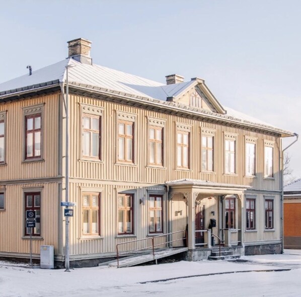 A two-story building with a symmetrical facade, large windows, and a central entrance with a porch. - Järnvägshotellet Skara City Stay (Skara)