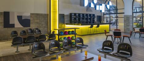 A bowling alley with multiple lanes, seating areas, and a bar with a neon sign.