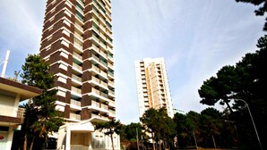 A tall, modern apartment building with a distinctive zigzag pattern on its facade. - Seafront flat with amazing view (Lignano Sabbiadoro)