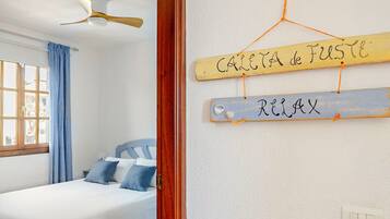 Ein Schlafzimmer mit einem Bett, einem Deckenventilator und einem an der Wand befestigten Schild mit Text.
