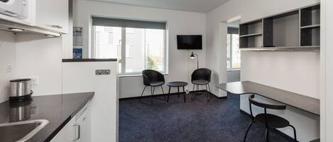 Une cuisine moderne équipée d’un four à micro-ondes, d’un évier et d’un petit coin repas avec des chaises et une table.