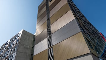 A modern building with a unique facade, featuring a mix of concrete and metal panels.