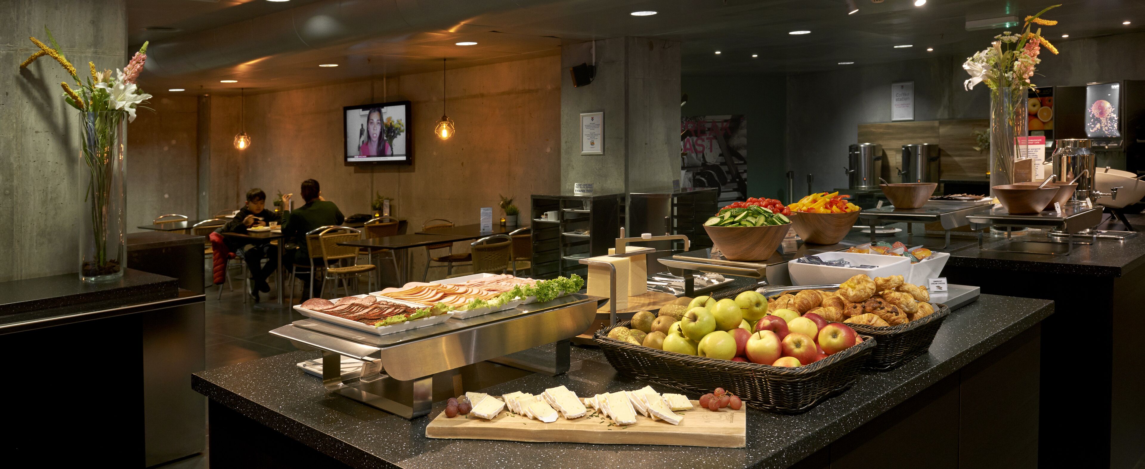 A buffet area with various food items, including fruits, cheeses, and pastries.