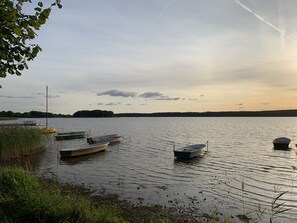 Un lac paisible où plusieurs bateaux sont amarrés le long de la rive.