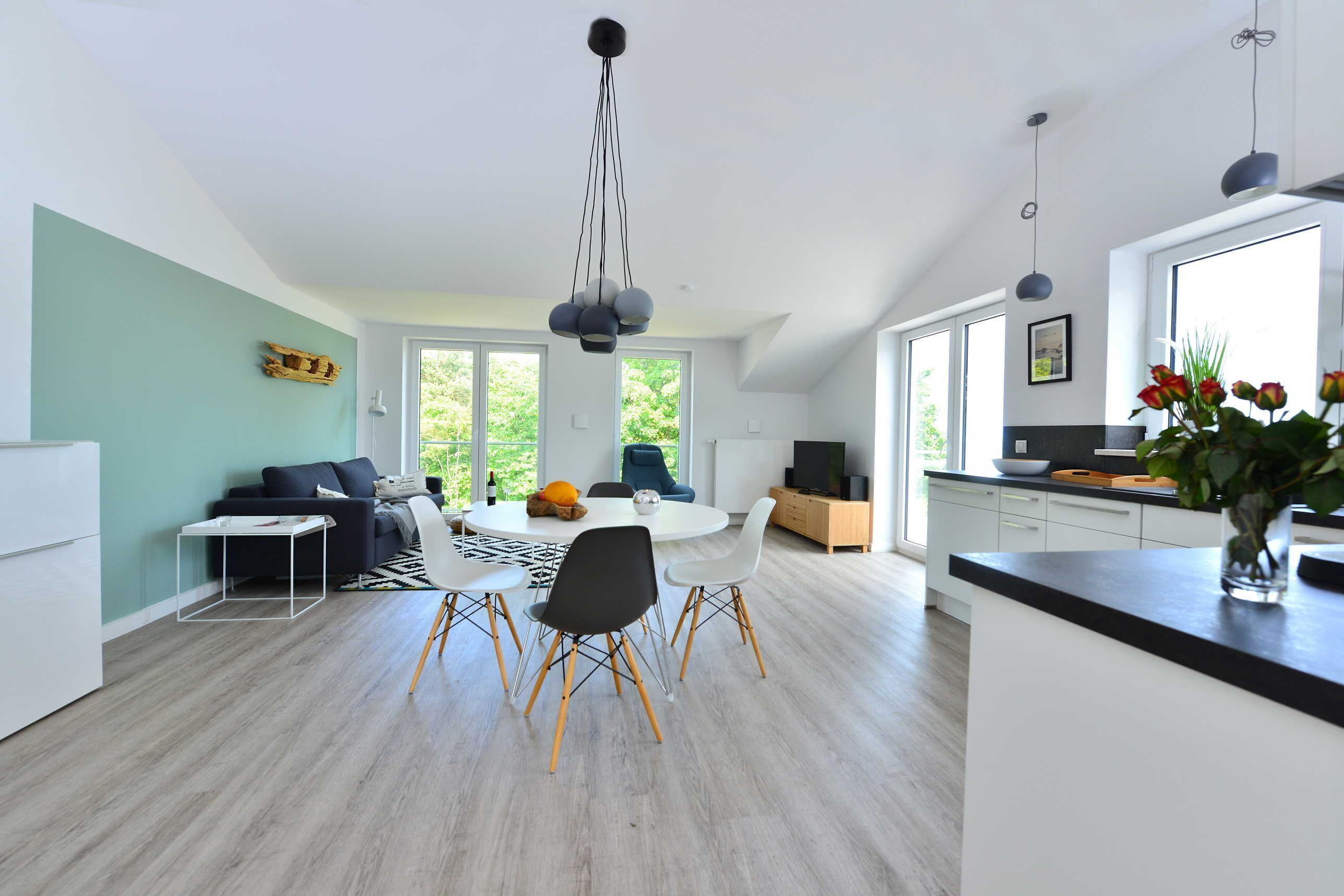 Una cocina moderna con comedor, ventanas amplias y vistas a zonas verdes.