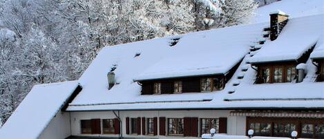 A snow-covered chair in a snowy outdoor area with a building in the background.