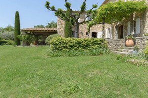 A stone house with a garden, a pergola, and a tall tree. - Mas des Papillons, Gordes (Gordes)
