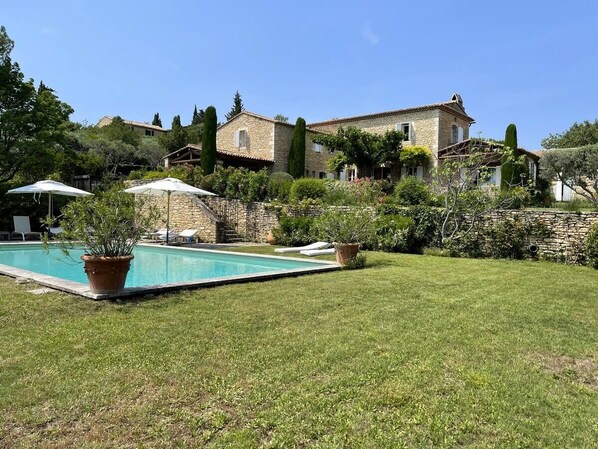 A stone villa with a swimming pool, surrounded by a well-maintained lawn and garden. - Mas des Papillons, Gordes (Gordes)