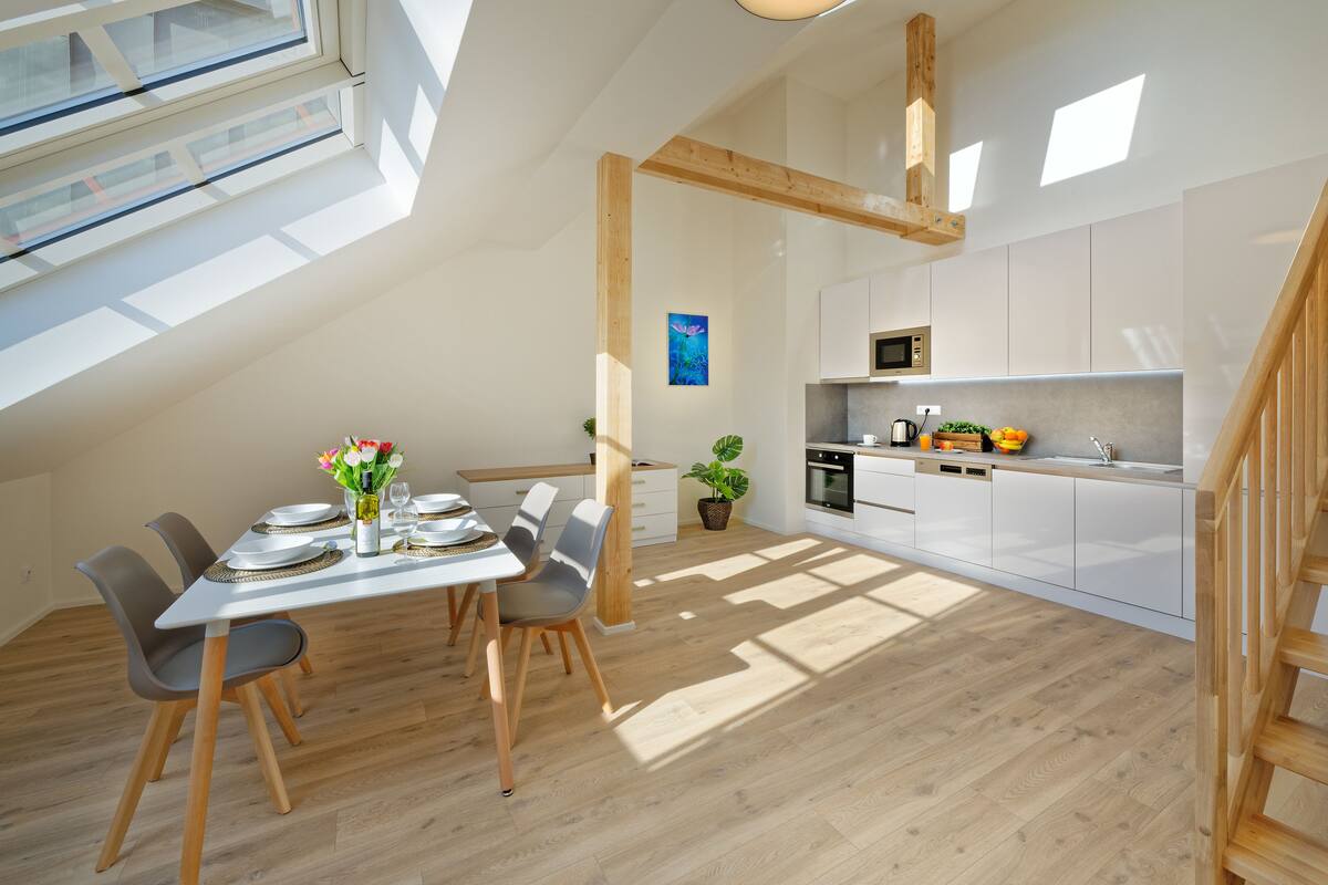 Moderni loft-tyylinen asunto, jossa on ruokailutila, keittiö ja portaikko.
