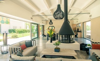 Amplia sala de estar con chimenea moderna, asientos cómodos y ventanas grandes que ofrecen vistas al exterior.