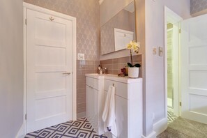 Deluxe appartement | Badkamer | Een douche, een regendouche, een haardroger, handdoeken