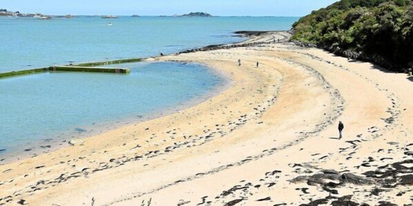 A beach with clear water, a curved shoreline, and rocky outcrops. - Hôtel Le Goas Plat (Paimpol)