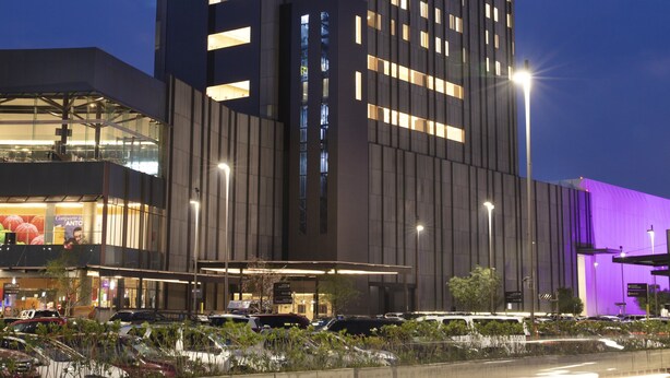 A modern hotel with a prominent 'Fiesta Inn' sign, a large parking area, and a well-lit facade. - Fiesta Inn Parque Puebla (Puebla)