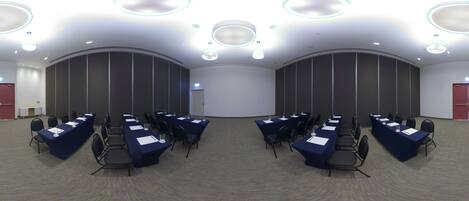A conference room with multiple tables and chairs, equipped with nameplates and water glasses.