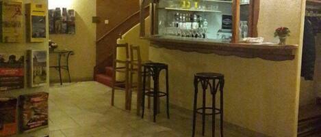 A kitchen with a bar area, a refrigerator, and a staircase.